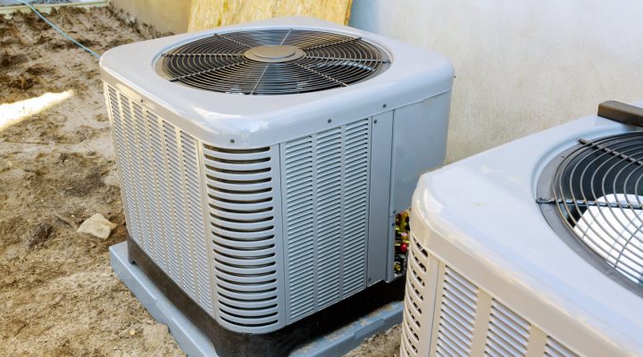 A heat pump unit mounted on a concrete base outdoors, designed for efficient heating and cooling.